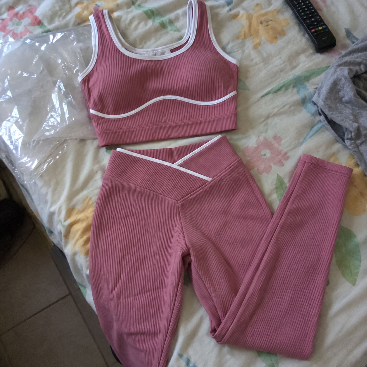 Conjunto rosa recém-chegado fotografado sobre a cama